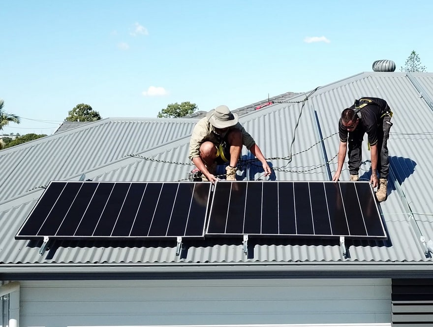 two men installing solar panels on a residential rooftop property