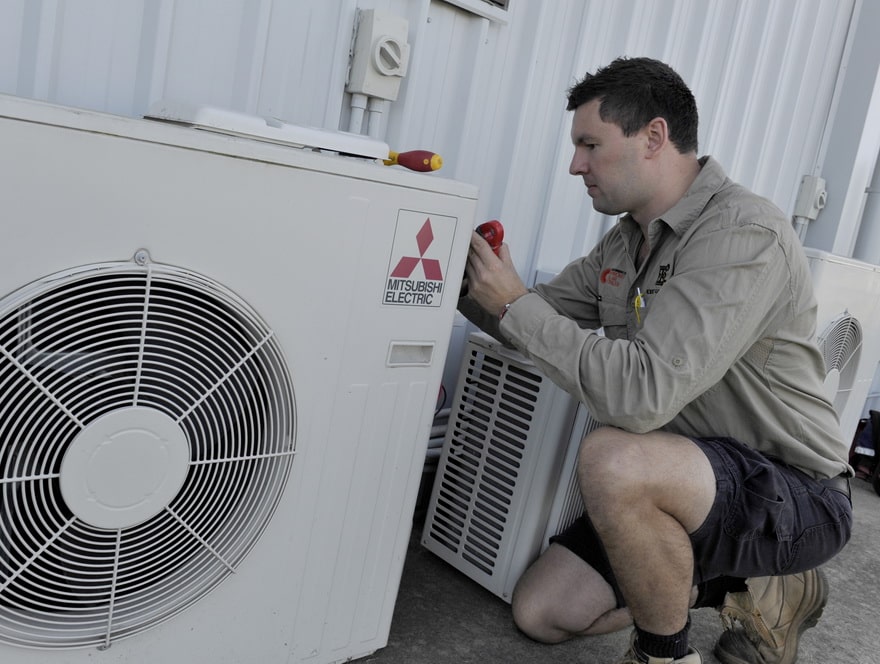 expert electrical employee setting up an air conditioning system at a commercial property