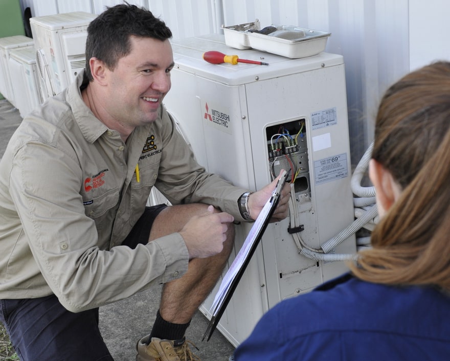 Expert electrical employee advising commercial client on air conditioners